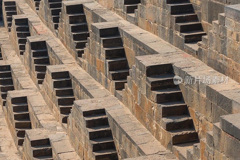 印度拉贾斯坦邦Abhaneri Chand Baori阶梯井的石楼梯背景透视图。梯级井，通过一组梯级下降到水平面到达水的井